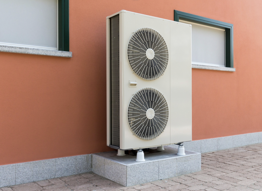 photo of a two fan heat pump outside an orange building